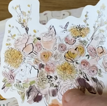 hand holding ephemera and affordable embellishment organization notebooks